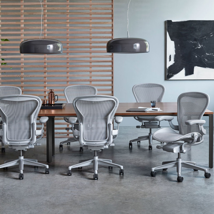 Herman Miller Layout Studio, tumma iso neuvottelutilan pöytä ja Aeron työtuolit.